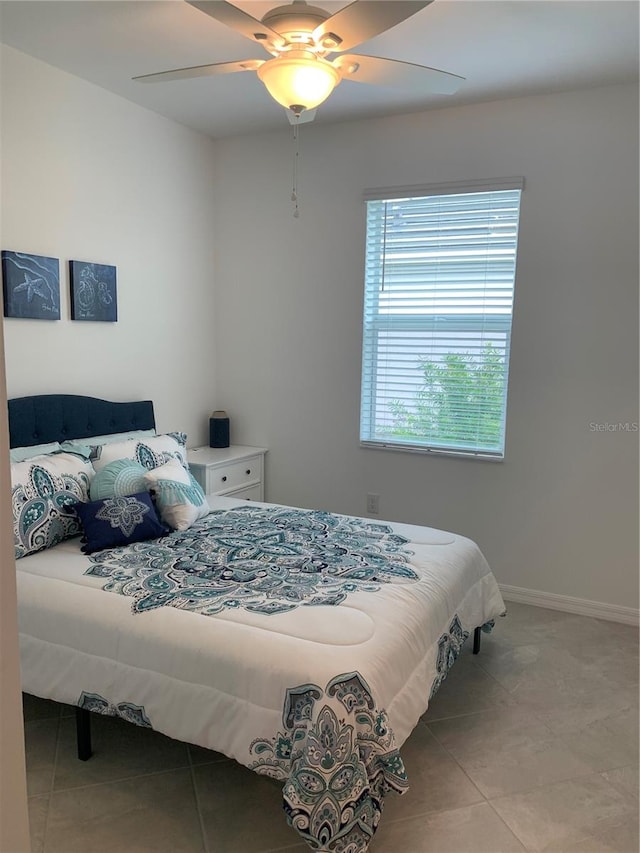 tiled bedroom featuring ceiling fan