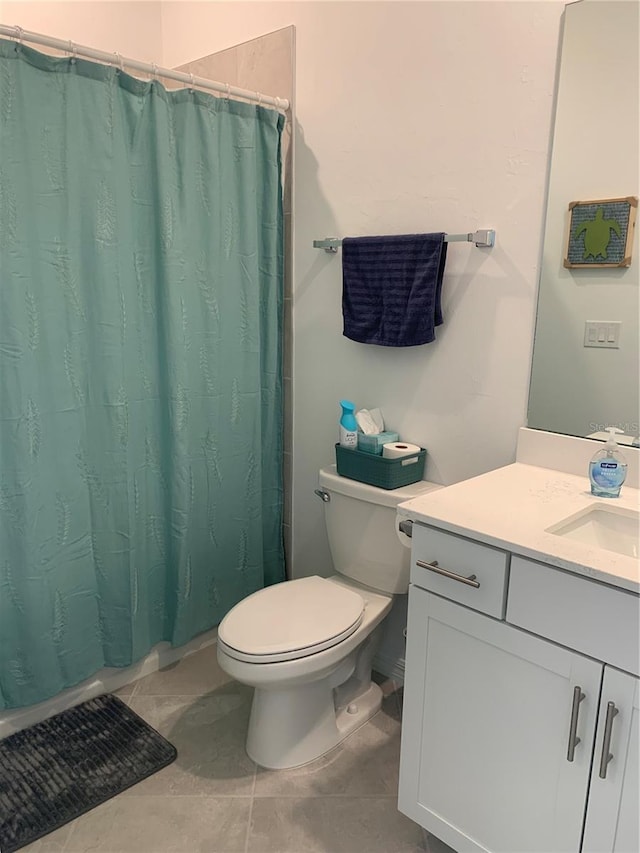 bathroom featuring vanity, toilet, and tile flooring