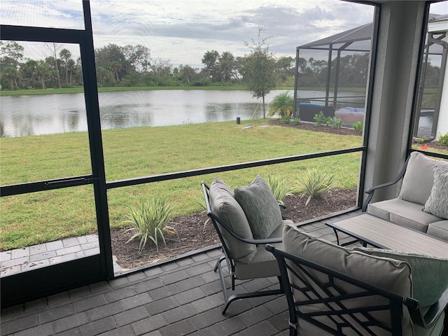 sunroom featuring a water view