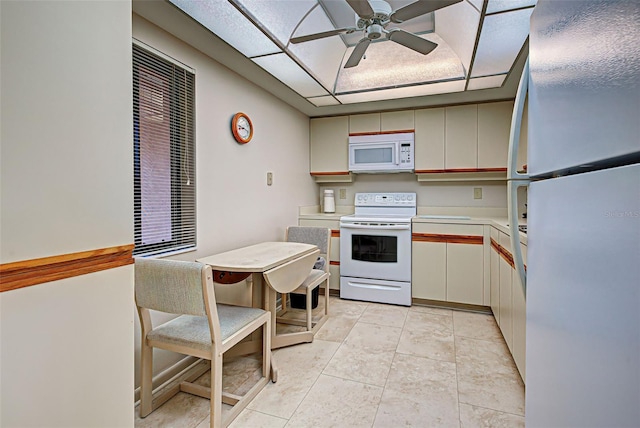 kitchen featuring ceiling fan, light tile patterned flooring, a drop ceiling, and white appliances