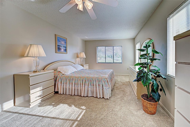 bedroom with light carpet, a textured ceiling, and ceiling fan