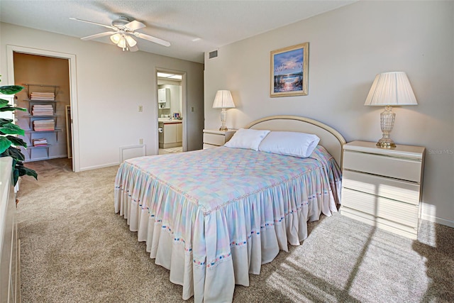 bedroom with ceiling fan, ensuite bath, and carpet