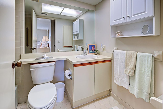 bathroom with vanity, toilet, and tile patterned flooring