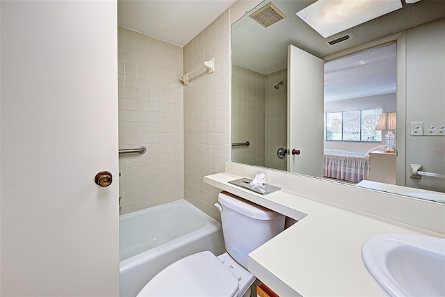 full bathroom with vanity, tiled shower / bath, and toilet