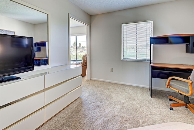 carpeted home office featuring a textured ceiling