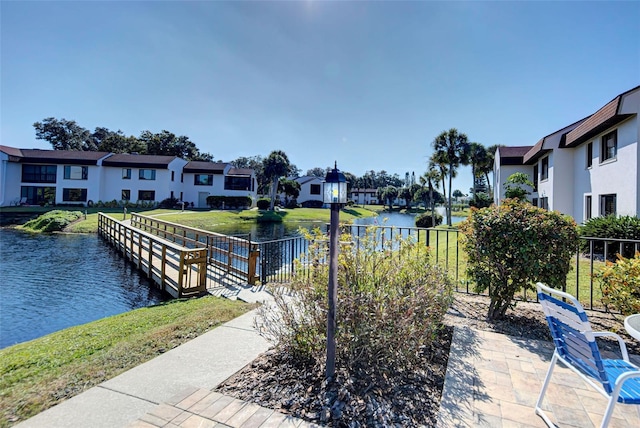 dock area featuring a water view and a lawn