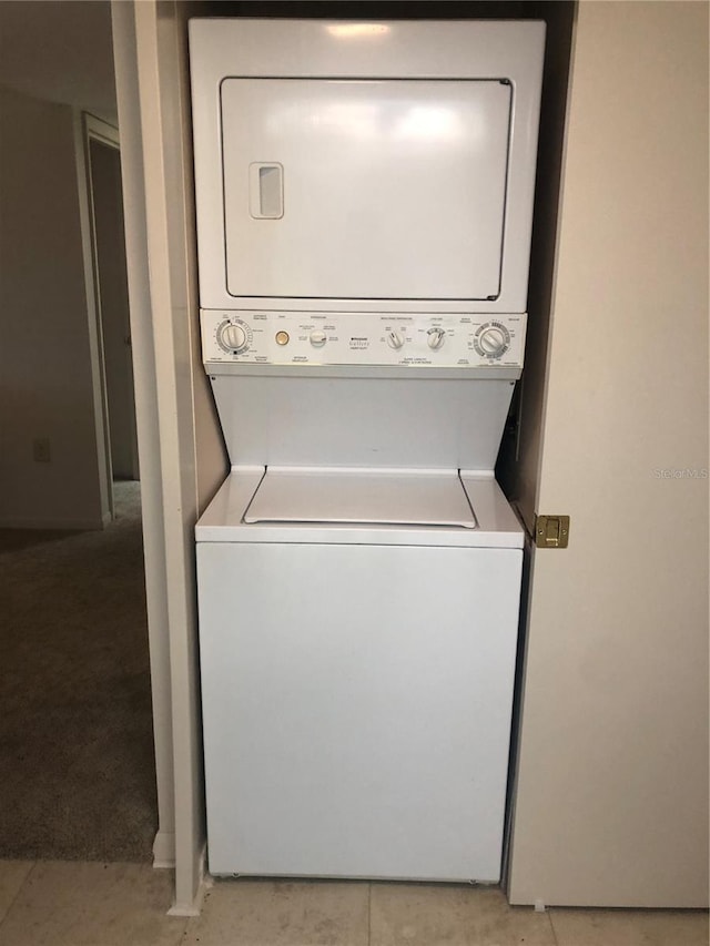 clothes washing area with stacked washing maching and dryer