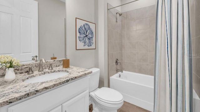 full bathroom with toilet, shower / bathtub combination with curtain, hardwood / wood-style floors, and vanity