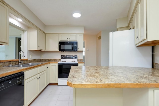 kitchen with sink, light tile patterned floors, black appliances, and cream cabinets