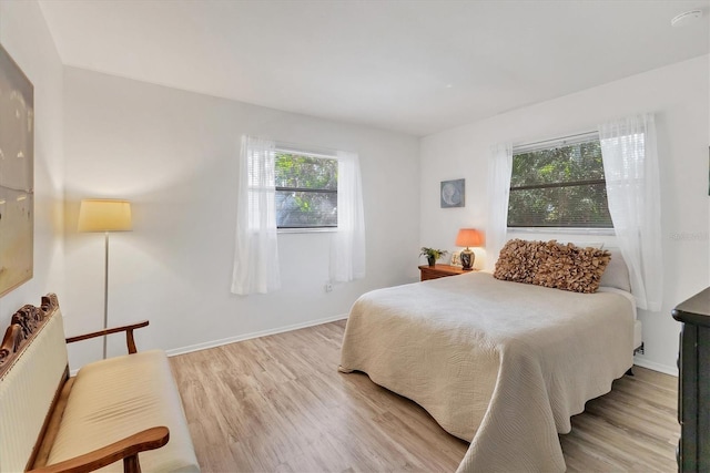 bedroom with radiator and light hardwood / wood-style flooring