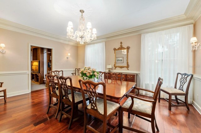 dining area featuring a healthy amount of sunlight, dark wood-type flooring, a chandelier, and ornamental molding