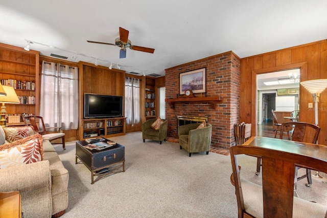 carpeted living room featuring a fireplace, wood walls, a wealth of natural light, and ceiling fan