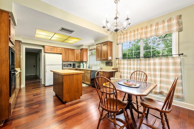 dining area featuring a notable chandelier, dark hardwood / wood-style flooring, and sink