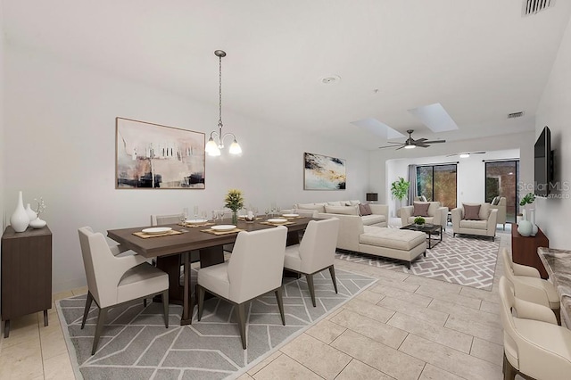 dining room featuring light tile patterned flooring and ceiling fan with notable chandelier