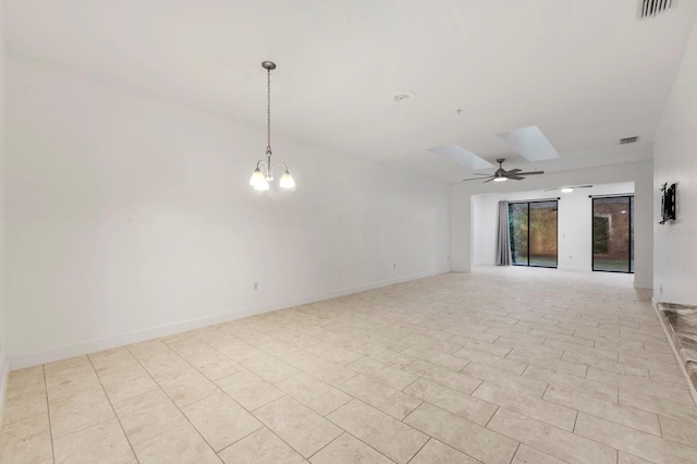 tiled spare room featuring ceiling fan with notable chandelier