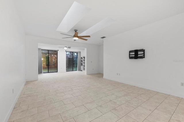 unfurnished room with a skylight, light tile patterned floors, and ceiling fan