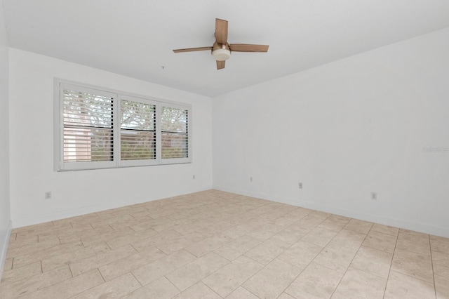 tiled spare room featuring ceiling fan