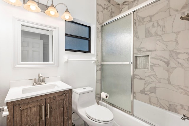 full bathroom featuring combined bath / shower with glass door, toilet, and vanity