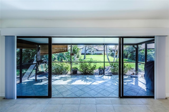 doorway with light tile floors and plenty of natural light