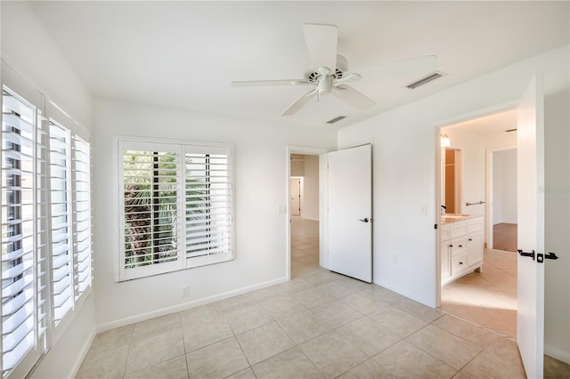 unfurnished bedroom featuring ceiling fan, connected bathroom, and light tile floors