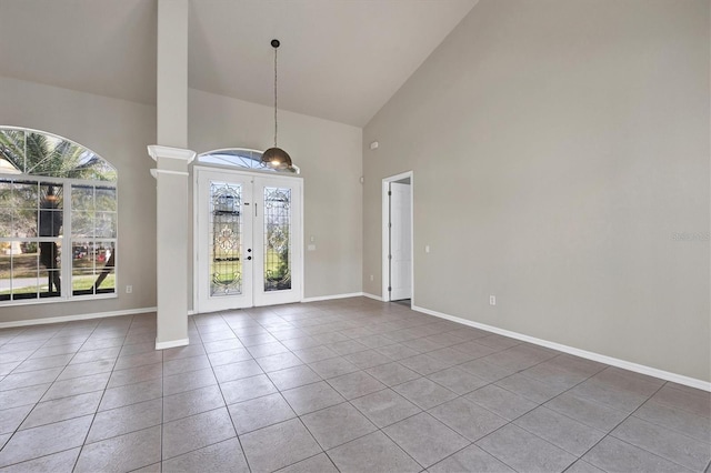 interior space with high vaulted ceiling, french doors, and ornate columns