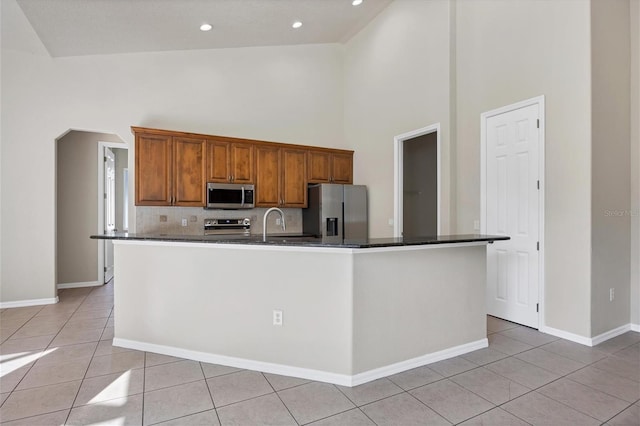 kitchen featuring high vaulted ceiling, tasteful backsplash, appliances with stainless steel finishes, and light tile floors