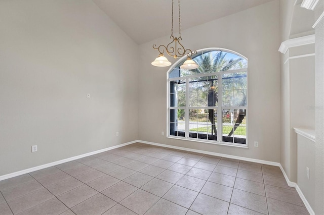 empty room featuring a chandelier, vaulted ceiling, light tile floors, and a wealth of natural light