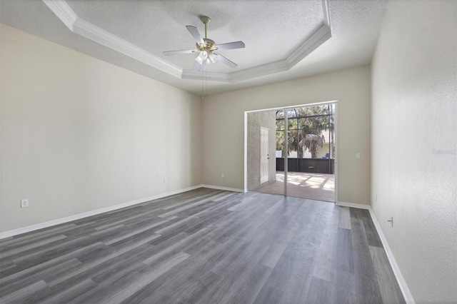 unfurnished room with ceiling fan, a textured ceiling, a raised ceiling, and dark hardwood / wood-style flooring