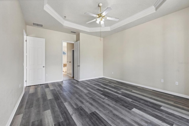 spare room featuring ceiling fan, a textured ceiling, dark hardwood / wood-style floors, and a raised ceiling