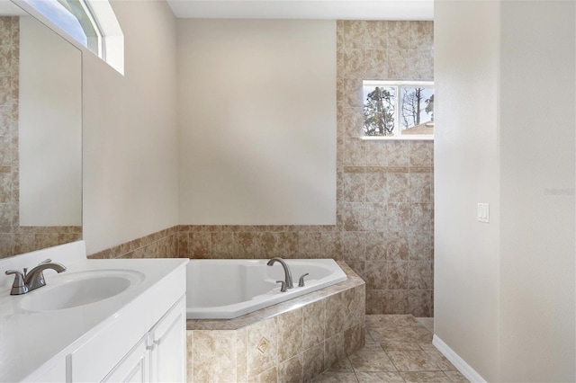 bathroom with tiled bath, tile walls, vanity with extensive cabinet space, and tile flooring