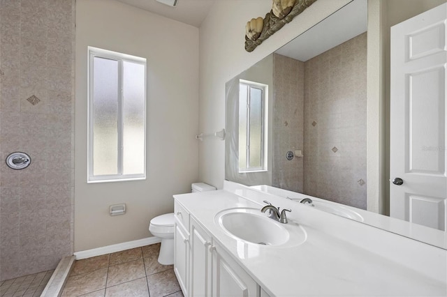 bathroom with a healthy amount of sunlight, vanity with extensive cabinet space, and tile flooring