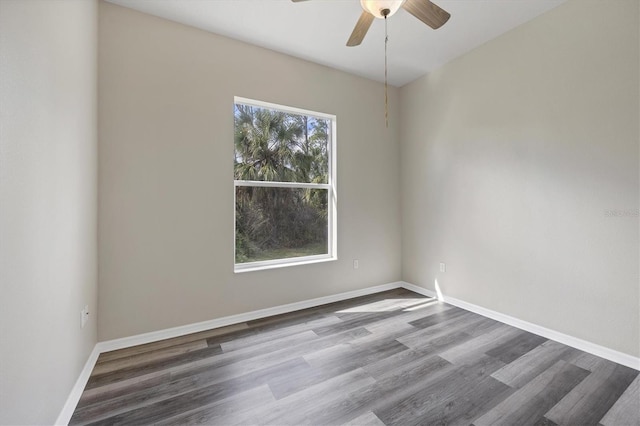 spare room with dark hardwood / wood-style flooring and ceiling fan