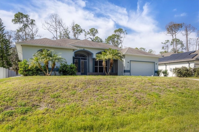 view of front of property with a front lawn, solar panels, and a garage