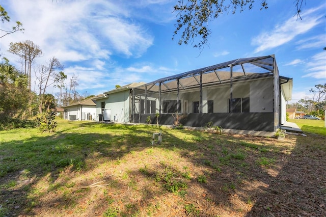 back of property with a yard and glass enclosure