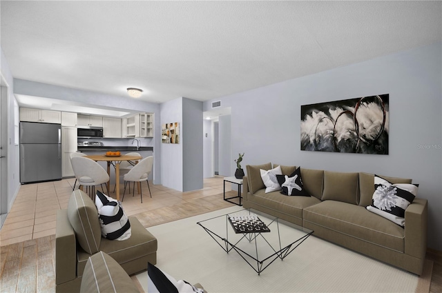 living room with sink and light hardwood / wood-style flooring