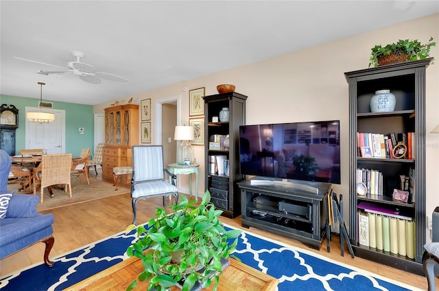 living room featuring ceiling fan and light wood-type flooring