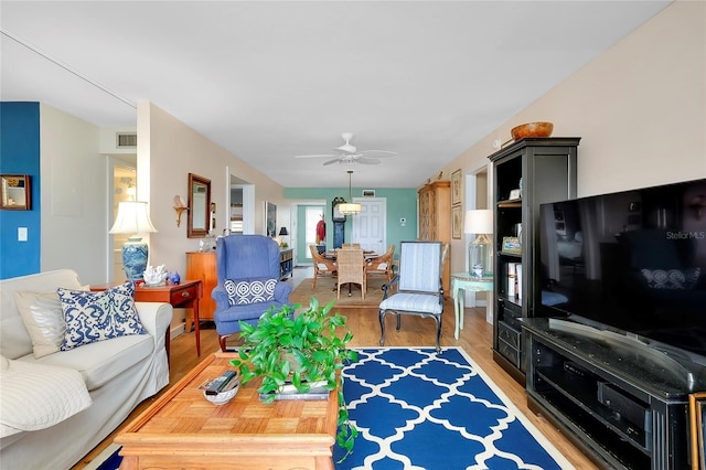 living room with light hardwood / wood-style floors and ceiling fan