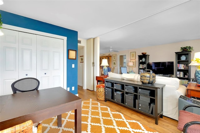 living room with light hardwood / wood-style flooring and ceiling fan