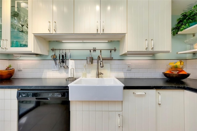 kitchen with black dishwasher, white cabinets, backsplash, and sink