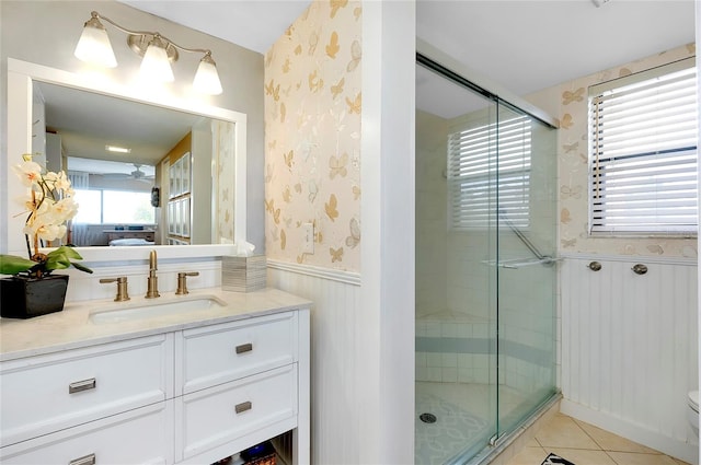 bathroom with a shower with door, tile floors, toilet, and vanity