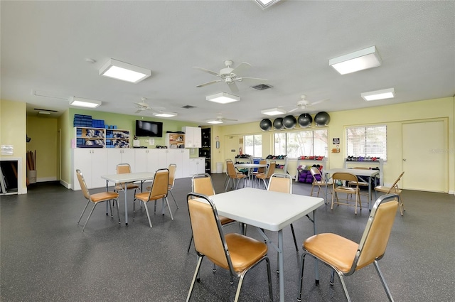 dining area with ceiling fan and a textured ceiling