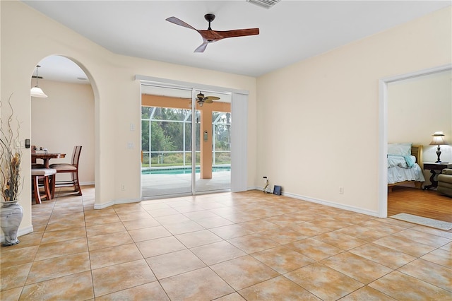 tiled spare room featuring ceiling fan