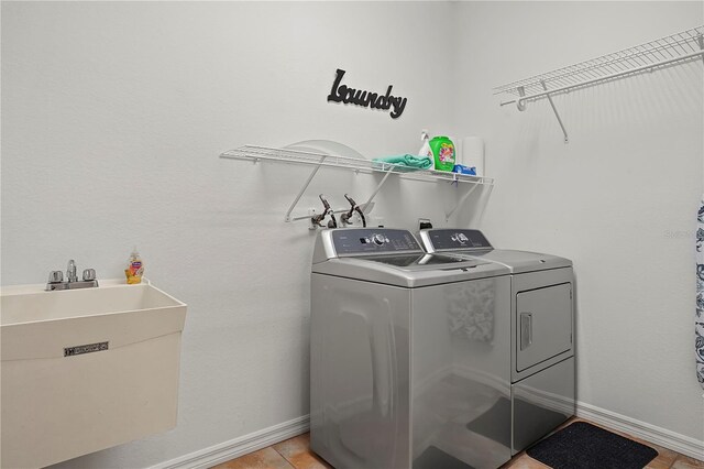 laundry area with washer and dryer, light tile flooring, hookup for a washing machine, and sink