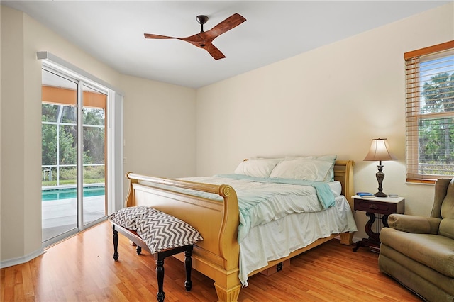 bedroom featuring multiple windows, access to exterior, and light hardwood / wood-style flooring