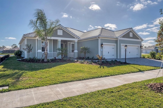 ranch-style house featuring a porch, a garage, and a front lawn