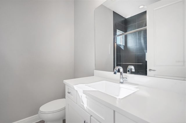 bathroom with vanity, toilet, and a shower with shower door