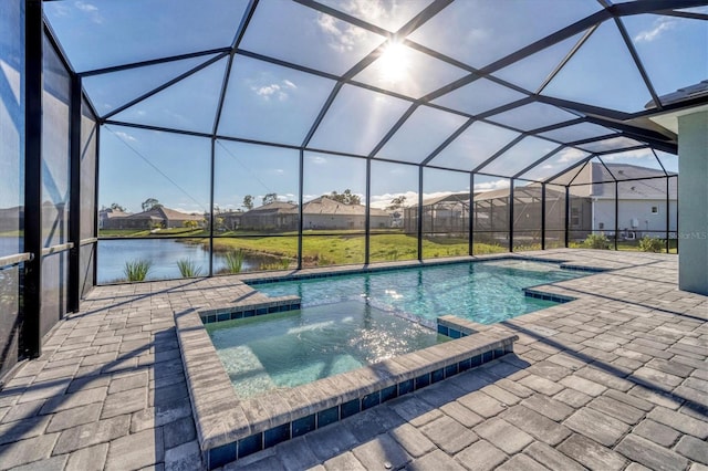 view of pool with glass enclosure, a water view, an in ground hot tub, and a patio