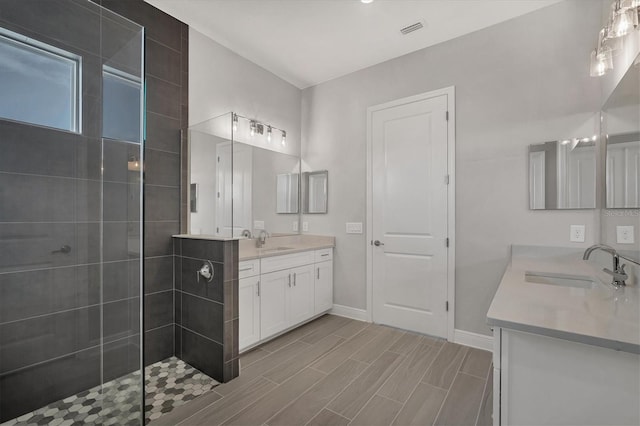 bathroom with vanity and a tile shower