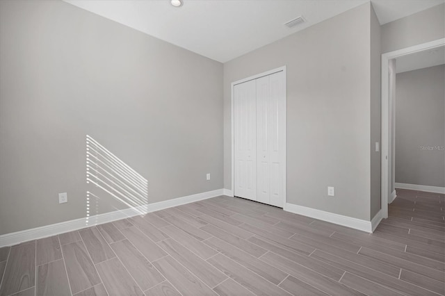 unfurnished bedroom featuring light hardwood / wood-style floors and a closet