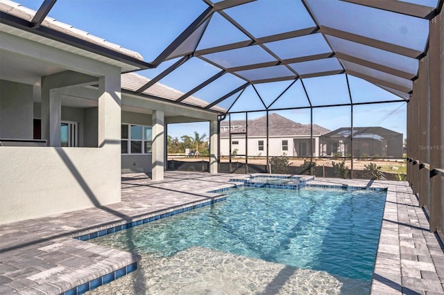 view of pool featuring a patio area, a lanai, and an in ground hot tub